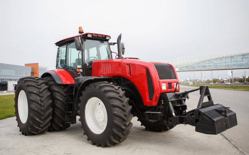 New Red modernized agricultural tractor with large wheels at the outdoor exhibition